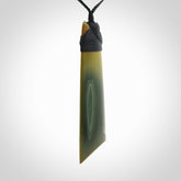 A large and beautiful hand carved toki pendant. This piece is carved from New Zealand flower jade by NZ Pacific. This is a wonderful large toki bound with a black cord and a traditional black lashing.